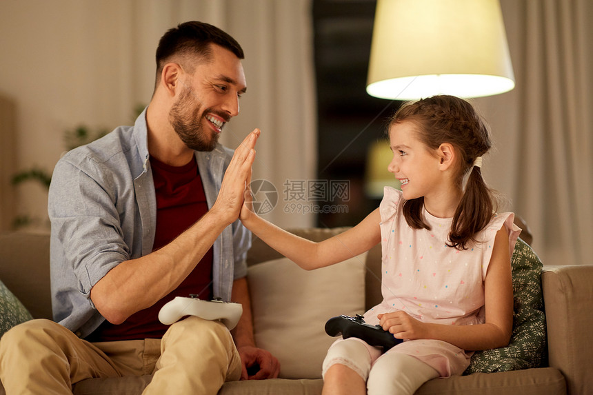 家庭游戏娱乐活动快乐的父亲小女儿,晚上家玩电子游戏父亲女儿家玩电子游戏图片