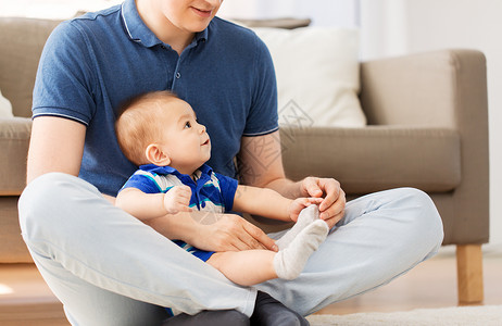 家庭,父亲童的快乐的父亲小儿子坐家里的地板上父亲小儿子坐家里的地板上图片