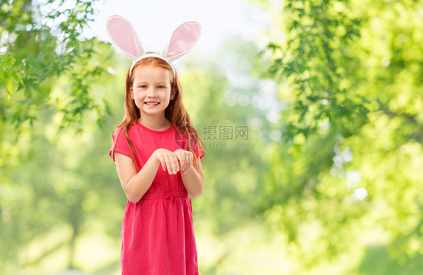 复活节,假期童的快乐的红头发女孩戴着兔子耳朵头巾绿色的自然背景快乐的红头发女孩戴复活节兔子耳朵图片
