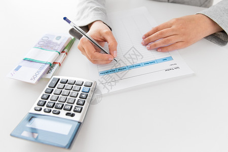 会计税务商业财务女商人与税务表格,计算器钱办公室桌子上把税单计算器钱放桌子上背景