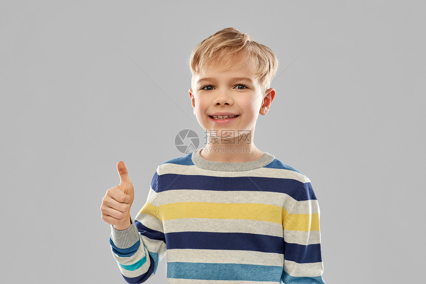 童,手势人的微笑的小男孩条纹套头衫拇指灰色背景穿着条纹套衫的微笑男孩竖大拇指图片