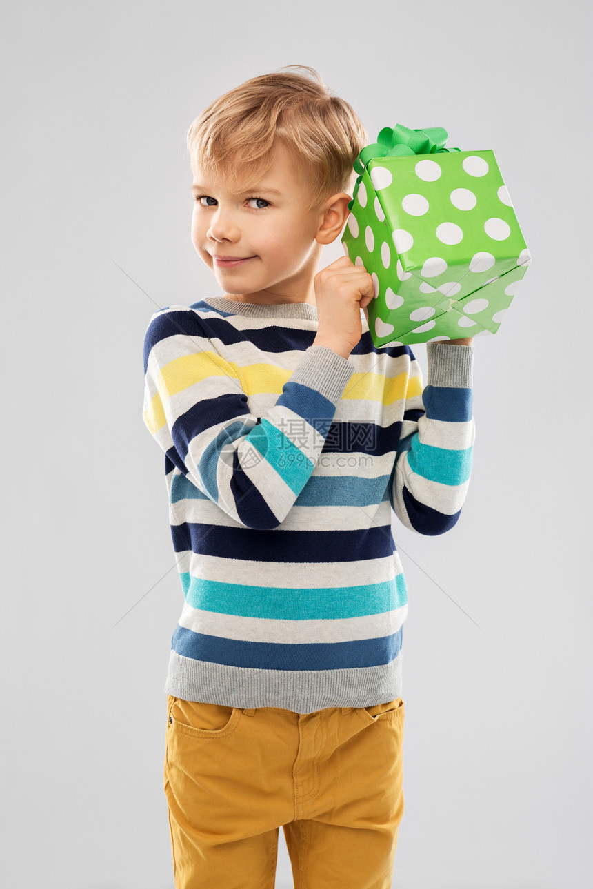 生日,童人的微笑的小男孩与礼品盒灰色背景带生日礼物盒的微笑男孩图片