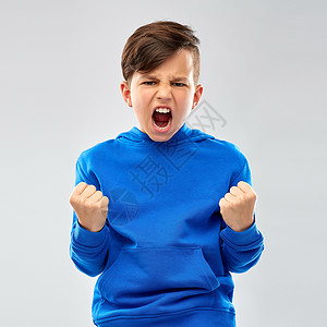 穿着蓝色帽衫的愤怒男孩庆祝成功背景图片