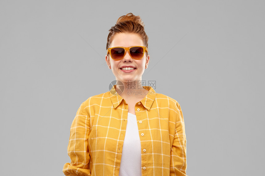 夏天,眼镜人的微笑的红色头发少女戴着太阳镜黄色格子衬衫灰色背景戴着太阳镜微笑的红头发少女图片