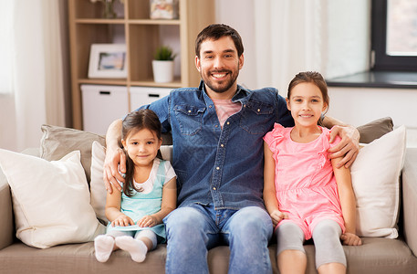 家庭,童父亲的幸福的父亲女儿沙发上家快乐的父亲女儿家里的沙发上图片