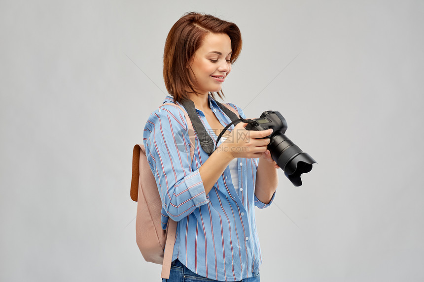 旅游,旅游摄影快乐的旅游妇女与背包相机灰色背景带背包相机的快乐旅游女人图片