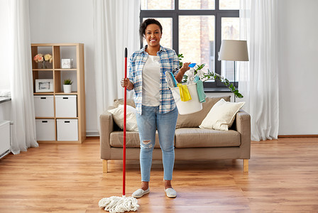 人,家务家务快乐的非裔美国妇女与拖把桶充满干净的东西家里家里拖把其他清洁用品的女人背景图片