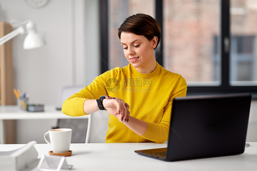 商业,技术时间管理快乐的微笑女商人用智能手表办公室快乐的女商人办公室用智能手表图片