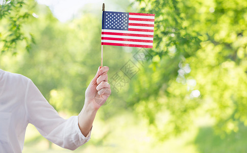 美国独立日庆祝独立日,庆祝,主义节日的绿色的自然背景下,7月4日,妇女手持美国的特写紧紧抓住手里着美国的女人背景