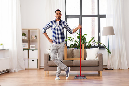 清洁,家务家务微笑的印度男子与扫帚家里微笑的印度男人,家里打扫扫帚图片