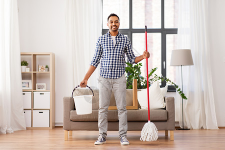 家庭,家务人的快乐的印度男子与拖把桶清洁地板家里家里拖把水桶的印度男人背景图片
