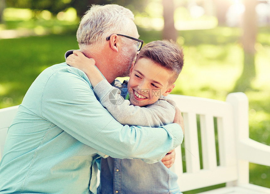 家庭世代关系人的快乐的祖父孙子夏天公园的长凳上拥抱祖父孙子夏天公园拥抱图片