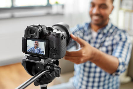 博客,视频博客设备微笑的印度男视频博客调整相机家印度视频博客调整相机图片
