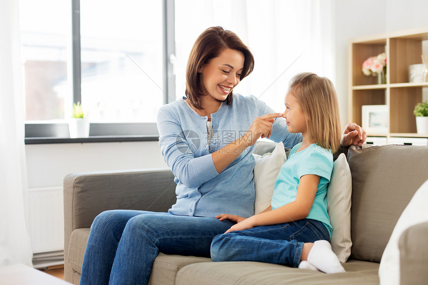 家庭世代人的快乐微笑的母亲女儿家里互相看着母亲女儿坐家里的沙发上图片