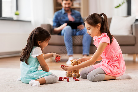 童休闲家庭观念小妹妹家里玩具陶器泰迪熊玩茶话会游戏女孩们家里玩玩具陶器泰迪背景图片