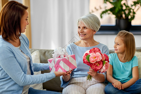 家庭世代生日快乐的母亲女儿家里给祖母送花礼物女家庭送给祖母的礼物女的高清图片素材