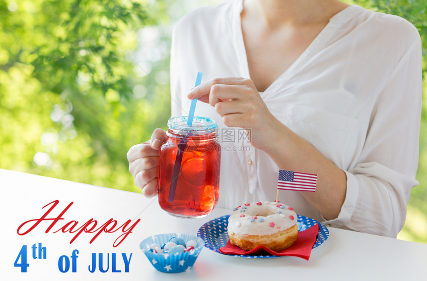 独立日,庆祝节日的7月4日的聚会上,绿色的自然背景下,用璃甜圈糖果果汁璃梅森罐杯子中妇女庆祝美国图片