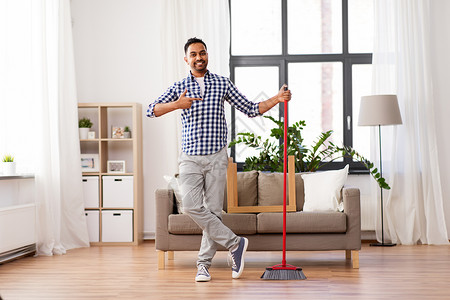 清洁,家务家务微笑的印度男子与扫帚家里微笑的印度男人,家里打扫扫帚图片