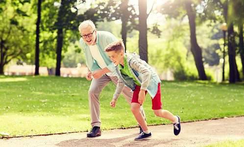 家庭世代人的快乐的祖父孙子夏季公园比赛祖父孙子夏季公园比赛图片