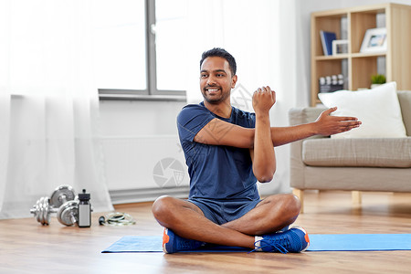运动,健身健康的生活方式印度男子训练伸展手臂家里男人家训练伸展手臂图片