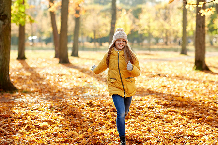 童,季节人的快乐的女孩秋天的公园跑步快乐的女孩秋天的公园里跑步图片