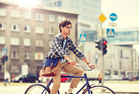 城市行动时尚男子骑固定齿轮自行车背景