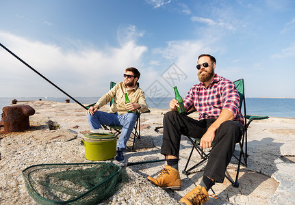 休闲人的快乐的男朋友海上码头钓鱼喝啤酒男朋友海上码头钓鱼喝啤酒图片