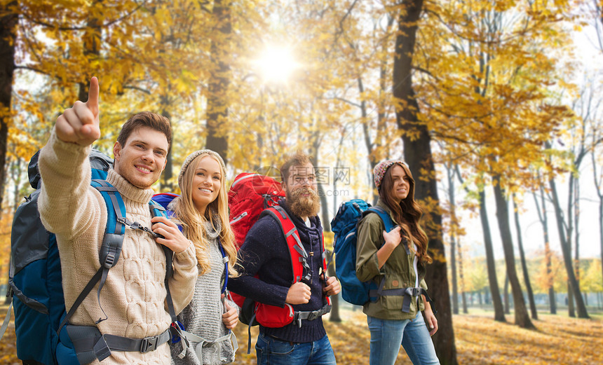 旅行,旅游徒步旅行的群微笑的朋友带着背包秋天的公园背景下散步朋友们带着背包秋天徒步旅行图片