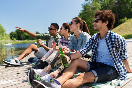 休闲,野餐人们的朋友湖墩喝啤酒苹果酒夏季公园朋友们湖边码头喝啤酒苹果酒图片