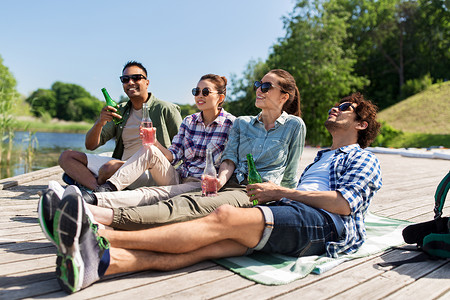 休闲,野餐人们的朋友湖墩喝啤酒苹果酒夏季公园朋友们湖边码头喝啤酒苹果酒图片