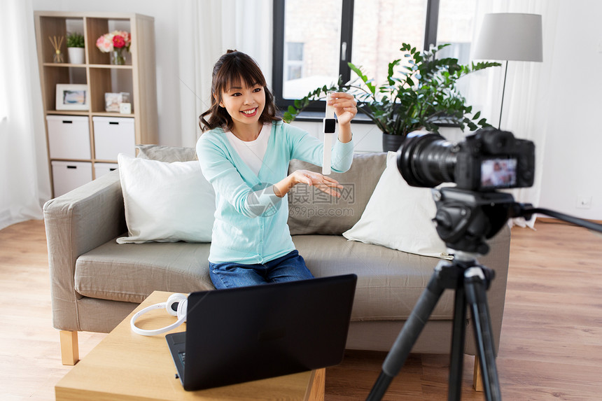 博客,技术视频博客快乐的微笑亚洲妇女博客与相机记录视频博客的智能手表家里亚洲博主制作智能手表视频博客图片