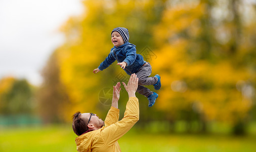 家庭,童父亲的快乐的父亲小儿子秋天的公园背景下玩户外玩父亲儿子秋天玩玩图片