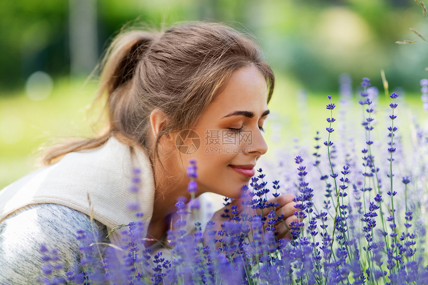 园艺人们的快乐的轻女人夏天的花园闻着薰衣草的花轻的女人花园里闻着薰衣草的花图片