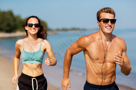运动太阳镜健身,运动技术快乐的夫妇与耳机运行夏季海滩夫妇带着耳机海滩上跑来跑背景