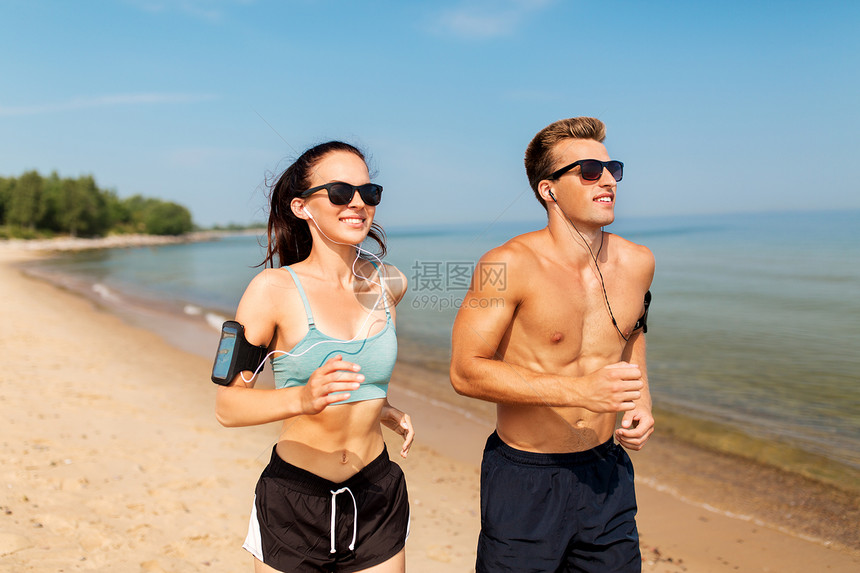 健身,运动技术快乐的夫妇与耳机手臂乐队运行夏季海滩夫妇带着电话手臂乐队海滩上跑步图片