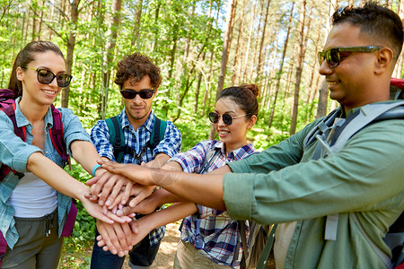 旅行,旅游,徒步旅行友谊的群朋友带着背包堆森林里背包的朋友把手堆森林里图片