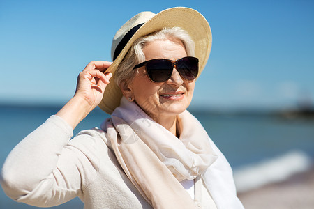 人休闲爱沙尼亚海滩上戴太阳镜草帽的快乐老妇女的肖像快乐的高级女人戴着太阳镜帽子海滩上生活方式高清图片素材