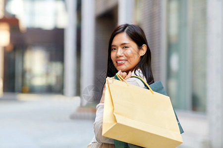 销售,消费主义人的轻的亚洲妇女与购物袋城市城市里带购物袋的亚洲女人图片