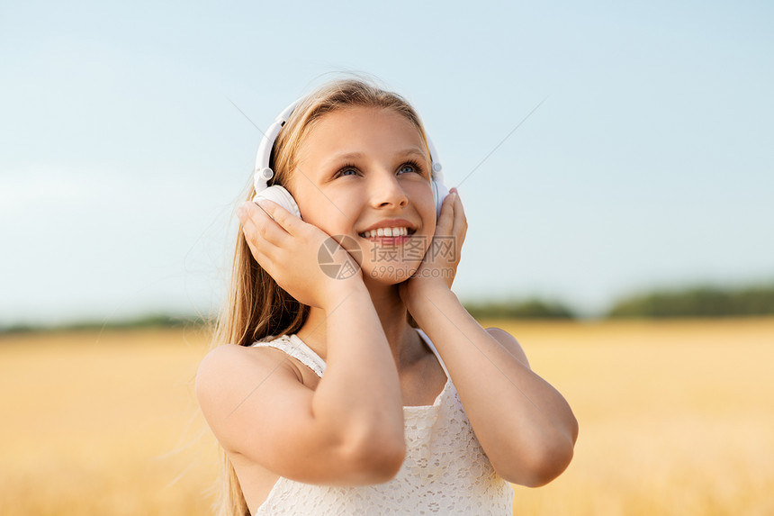 技术人的快乐女孩的肖像耳机谷物领域听音乐夏天夏天谷物地里戴耳机的快乐女孩图片