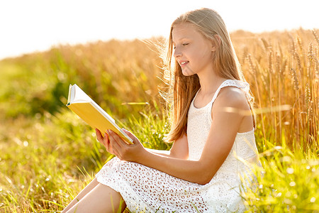乡村,文学休闲微笑的轻女孩穿着白色连衣裙阅读书谷谷田夏天微笑的轻女孩读谷物领域的书背景图片