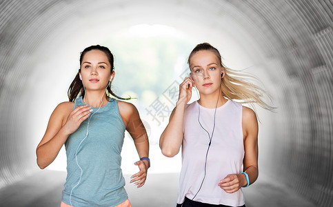 健身,运动健康的生活方式轻的妇女女朋友与耳机运行户外耳机运行的女女朋友背景图片