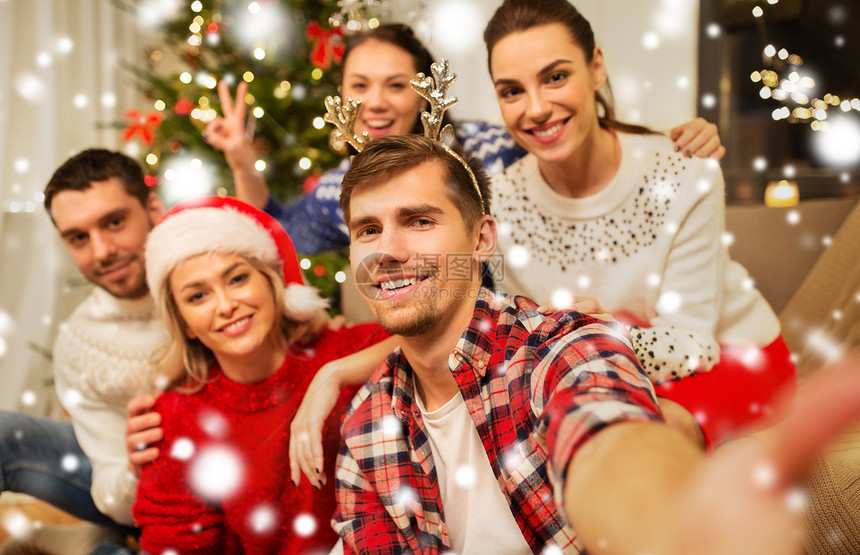 庆祝假期快乐的朋友戴着眼镜,家里的聚会上庆祝诞节,雪地上自拍朋友们庆祝诞节自拍图片