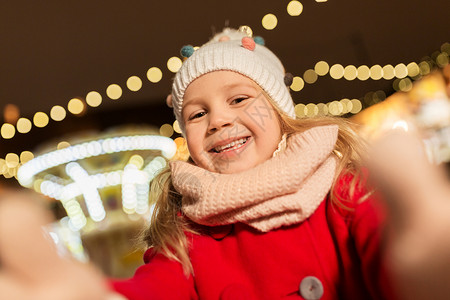 假期,童人的快乐的小女孩诞节市场冬天的晚上自拍小女孩诞节市场自拍背景图片