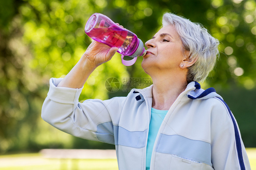 健身,运动健康的生活方式口渴的老妇女公园锻炼后瓶子里喝水老年女子公园锻炼后喝水图片