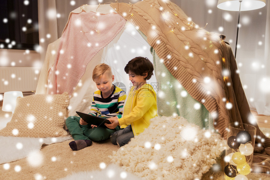童,技术快乐的小男孩与平板电脑电脑孩子们帐篷家里的雪孩子们家帐篷里着平板电脑的小男孩图片