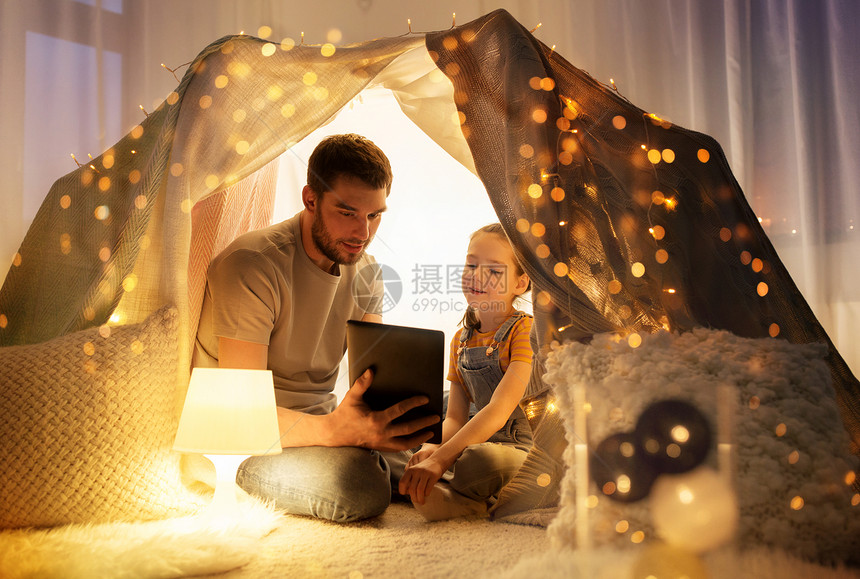 诞节父亲女儿帐篷里用平板电脑图片