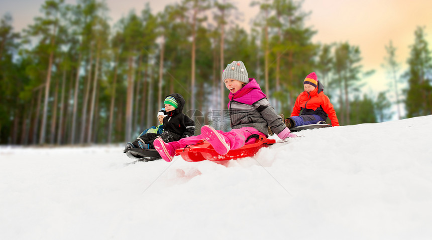 快乐的孩子们雪山上滑雪橇图片