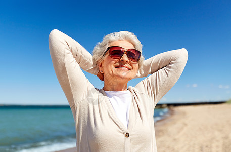 人休闲爱沙尼亚海滩上戴太阳镜的快乐老妇女的肖像海滩上戴太阳镜的高级女人的肖像古老的高清图片素材