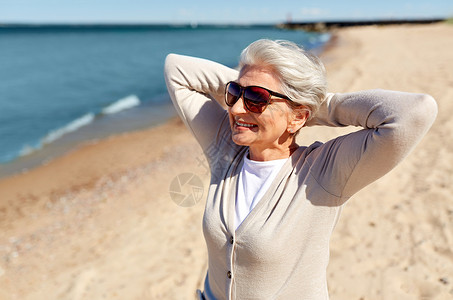 人休闲爱沙尼亚海滩上戴太阳镜的快乐老妇女的肖像海滩上戴太阳镜的高级女人的肖像夏天高清图片素材