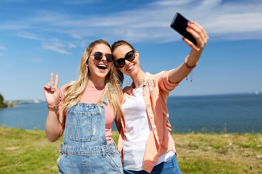 休闲友谊快乐微笑的十几岁女孩最好的朋友太阳镜拥抱自拍智能手机海边夏天十几岁的女孩朋友夏天自拍图片